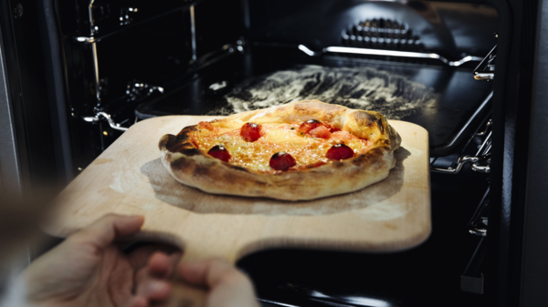 Frisch gebackene Pizza wird aus dem NEFF Backofen genommen