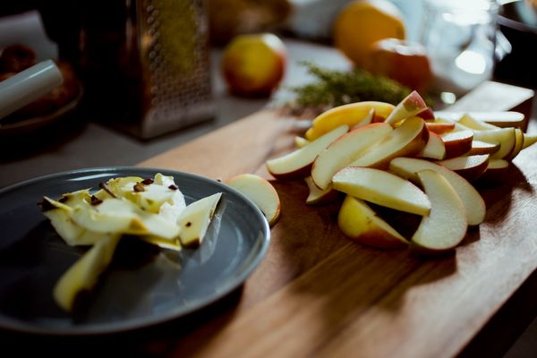 Fette di mela appena tagliate su tagliere di legno in cucina