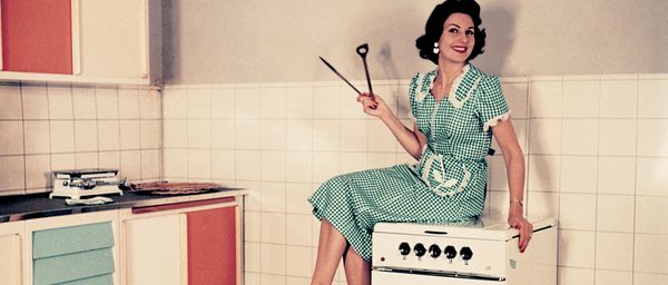 Retro kitchen setting with lady sat on NEFF appliance