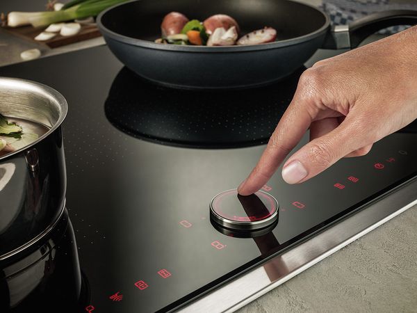 Person using NEFF TwistPad feature on NEFF Induction Hob