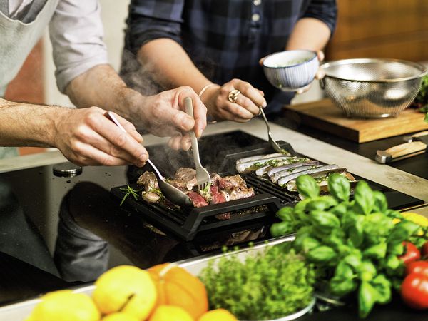 People cooking with NEFF FlexInduction hob