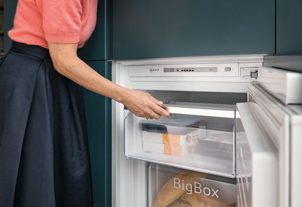 A spacious kitchen with a side-by-side fridge, the doors of which are open