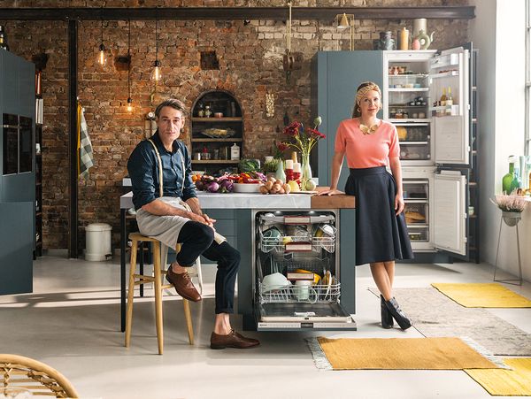 Man and woman in kitchen scene with NEFF built-in appliances