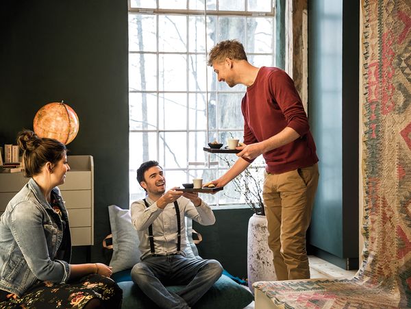 Man serving coffee to friends brewed in NEFF built-in bean-to-cup coffee machine