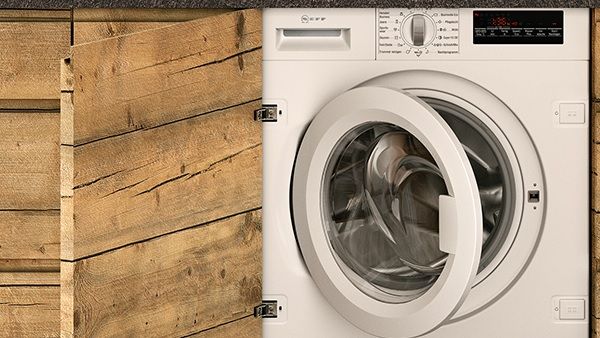 A washing machine located in a kitchen with wooden walls, showcasing a blend of functionality and rustic design.  