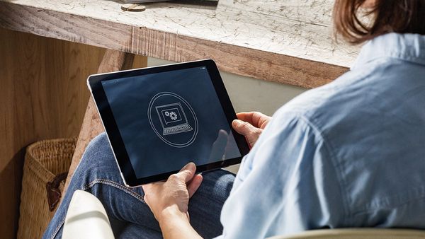 Woman using NEFF oven App on Tablet device remotely