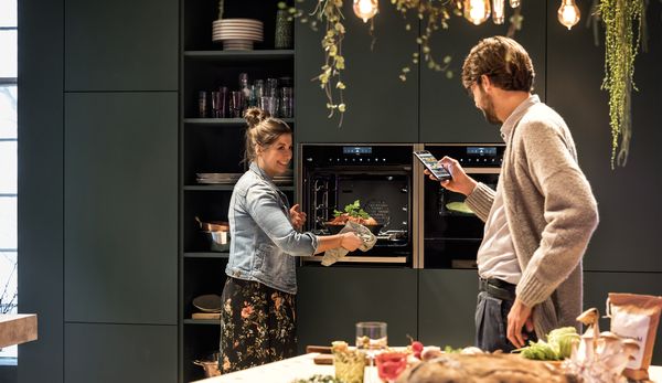 People using NEFF connected oven with mobile phone