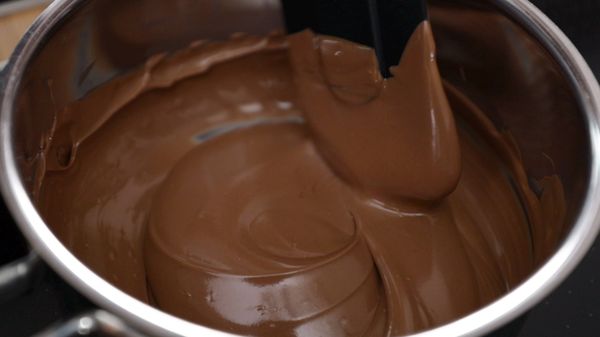 Stirring melted milk chocolate in a pan