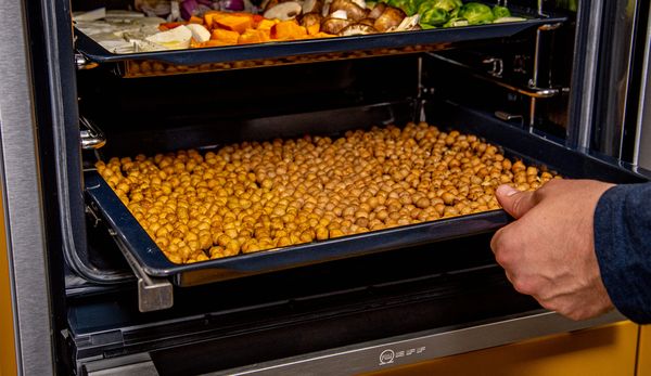Popping chickpeas on a tray into the NEFF oven