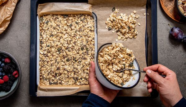 Transfering the granola to a parchment-lined baking dish