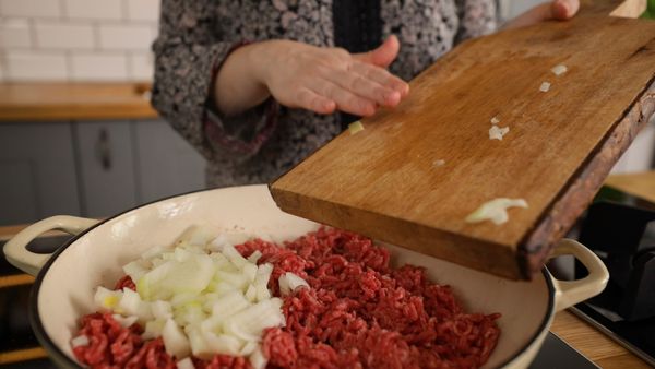Adding onion and mince to oven proof pan
