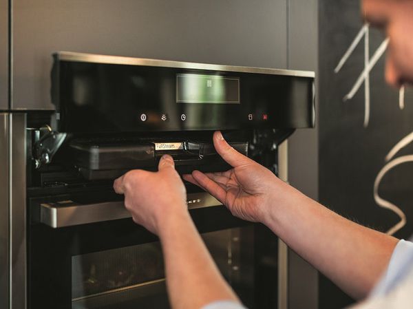 Man removing steam tray from NEFF Steam Oven