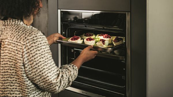 Woman using Slide&Hide oven to cook