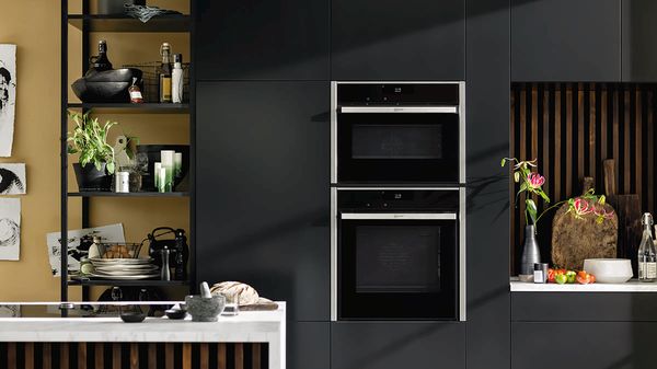 Dark designed kitchen with combined appliances